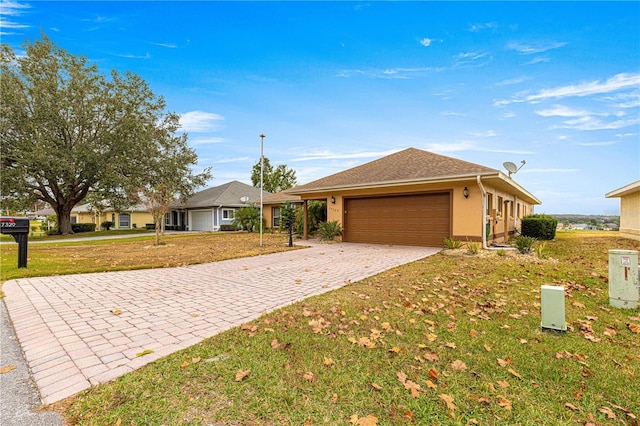 single story home featuring a garage and a front lawn