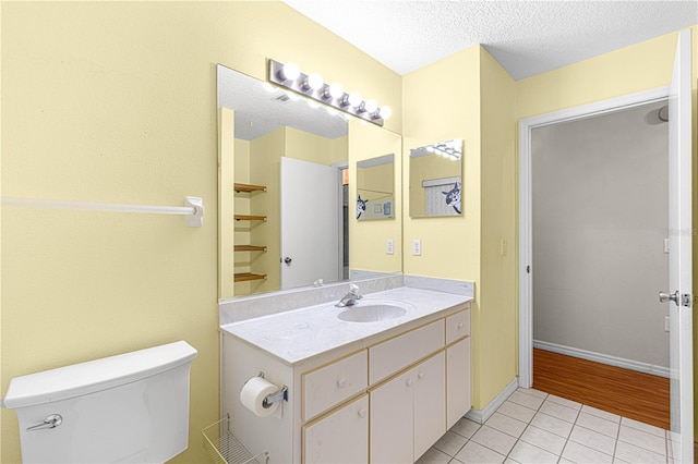 bathroom featuring hardwood / wood-style flooring, vanity, toilet, and a textured ceiling