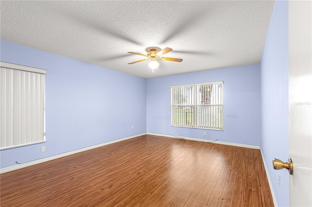 unfurnished room featuring ceiling fan, wood-type flooring, and a textured ceiling