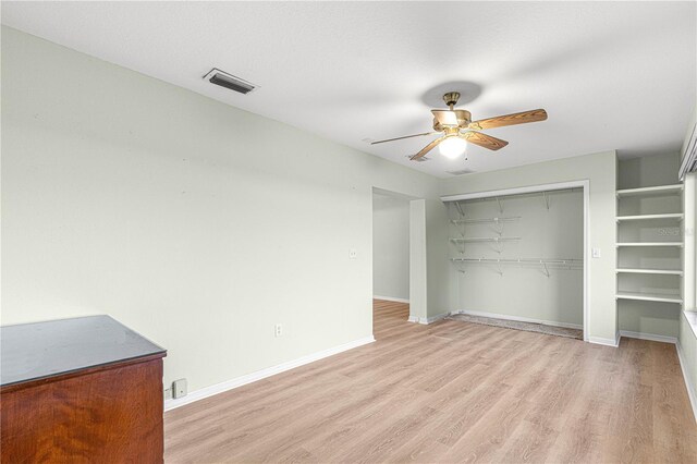 unfurnished bedroom with a closet, light hardwood / wood-style flooring, and ceiling fan