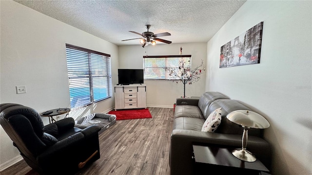 living room with hardwood / wood-style flooring, ceiling fan, and a textured ceiling