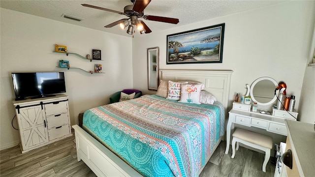 bedroom featuring wood-type flooring, a textured ceiling, and ceiling fan