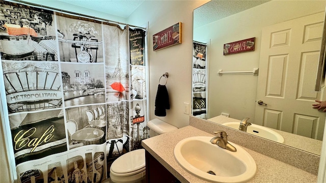 bathroom featuring a shower with curtain, vanity, and toilet