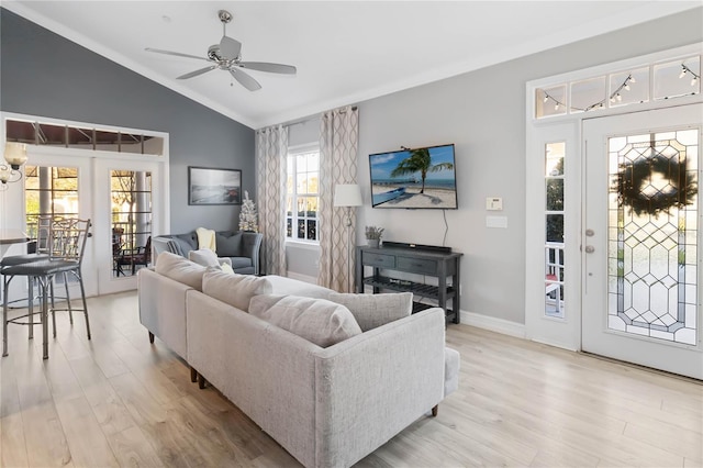 living room with ceiling fan, light wood-type flooring, crown molding, and vaulted ceiling