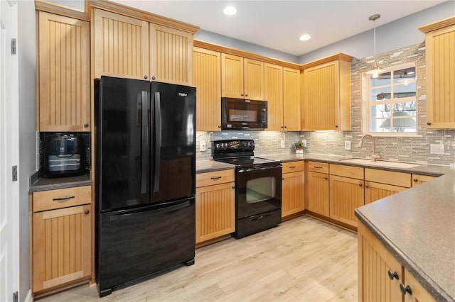 kitchen featuring tasteful backsplash, sink, black appliances, pendant lighting, and light hardwood / wood-style floors