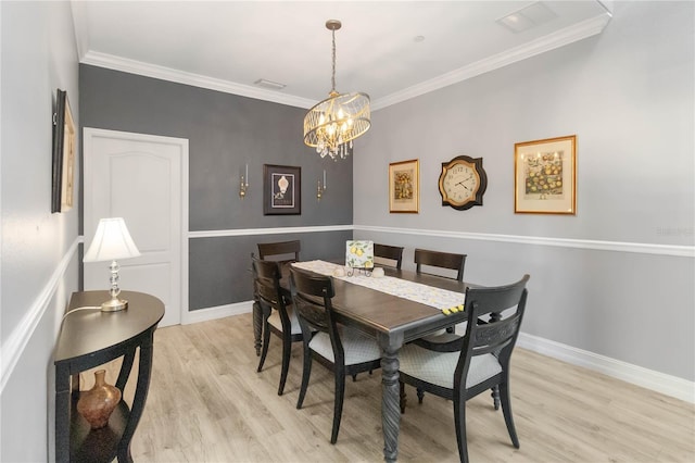 dining room featuring an inviting chandelier, crown molding, and light hardwood / wood-style flooring