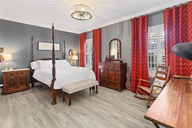 bedroom with crown molding, light hardwood / wood-style flooring, and an inviting chandelier