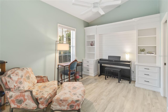 living area featuring ceiling fan, light hardwood / wood-style floors, and vaulted ceiling