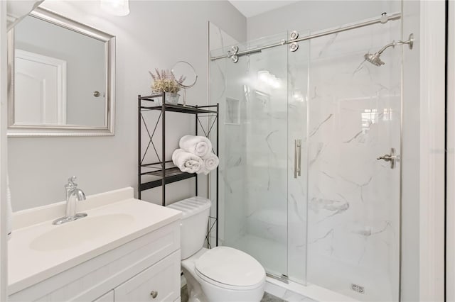 bathroom with vanity, toilet, and a shower with door