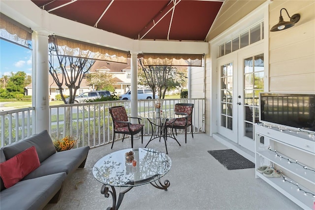 sunroom / solarium featuring a wealth of natural light, french doors, and vaulted ceiling