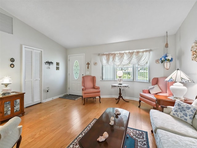 living room with hardwood / wood-style floors and vaulted ceiling