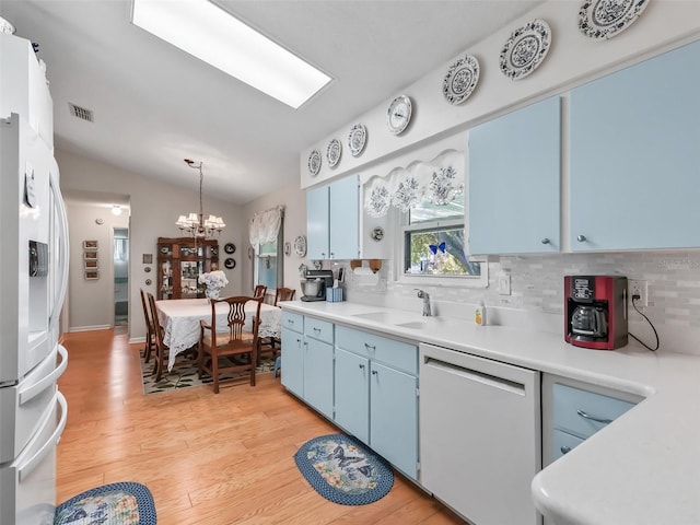 kitchen with blue cabinetry, light hardwood / wood-style flooring, and white appliances