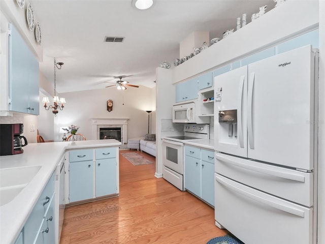 kitchen with blue cabinets, pendant lighting, white appliances, light hardwood / wood-style floors, and ceiling fan with notable chandelier