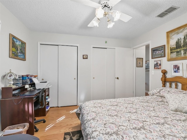 bedroom featuring ceiling fan, a textured ceiling, and light wood-type flooring