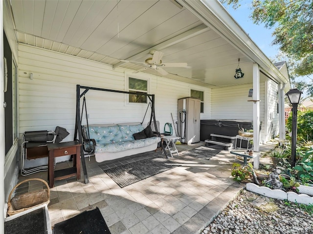 view of patio with ceiling fan and a hot tub