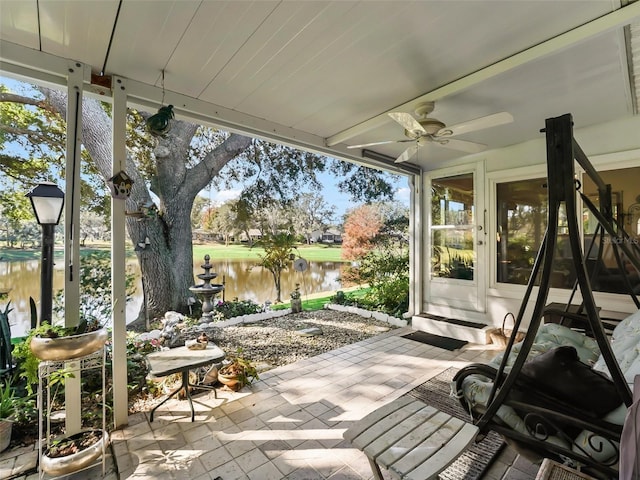 sunroom with a water view and ceiling fan