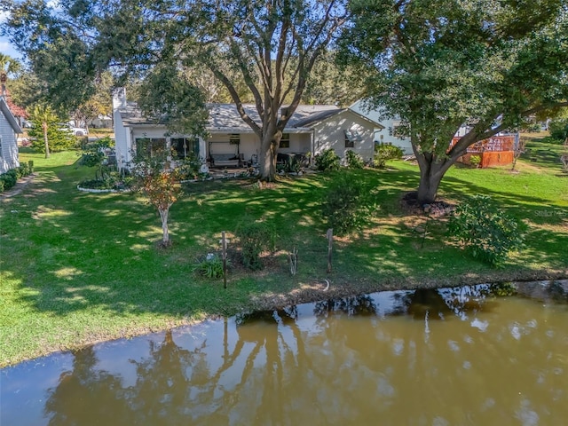 rear view of property featuring a water view and a yard