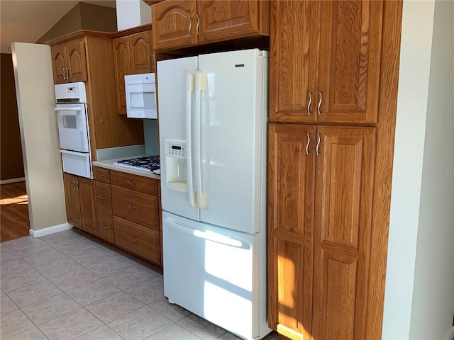 kitchen with light tile patterned flooring and white appliances