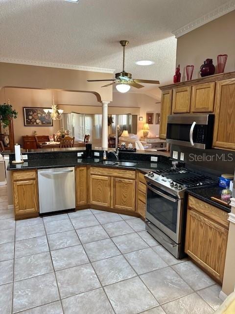 kitchen featuring sink, stainless steel appliances, kitchen peninsula, a textured ceiling, and lofted ceiling