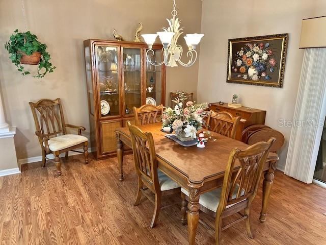 dining room with hardwood / wood-style flooring and an inviting chandelier