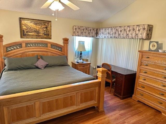 bedroom featuring hardwood / wood-style floors, a textured ceiling, ceiling fan, and lofted ceiling