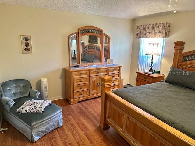 bedroom featuring a textured ceiling and light hardwood / wood-style floors