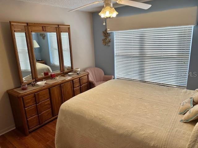 bedroom featuring a textured ceiling, dark hardwood / wood-style flooring, and ceiling fan