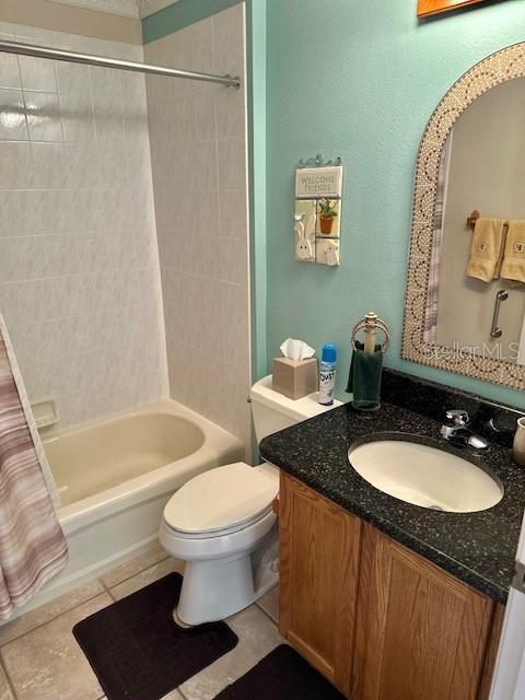 full bathroom featuring toilet, shower / bath combo, vanity, and tile patterned floors