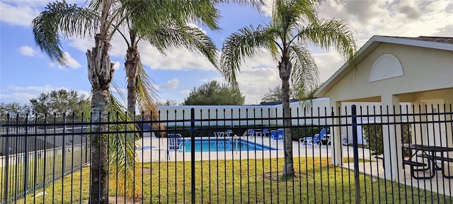 community pool featuring a yard and fence