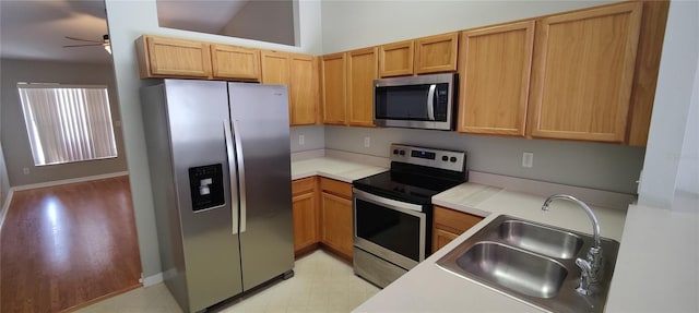 kitchen featuring a ceiling fan, light floors, a sink, light countertops, and appliances with stainless steel finishes