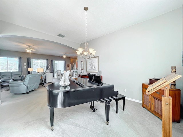 miscellaneous room featuring light carpet and ceiling fan with notable chandelier