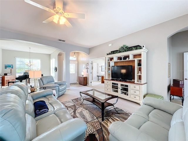 living room featuring ceiling fan with notable chandelier and light colored carpet