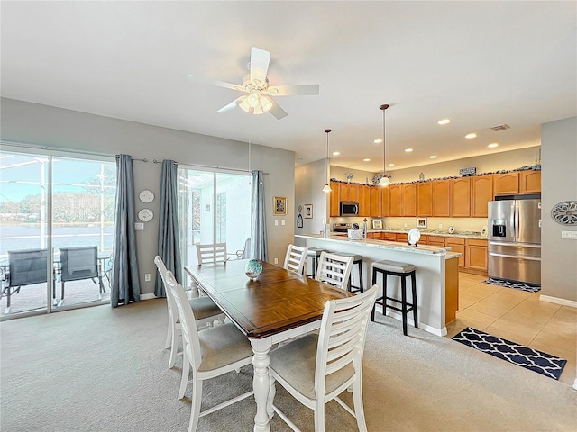 carpeted dining room featuring ceiling fan