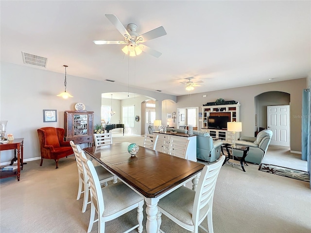 dining room featuring ceiling fan and light carpet