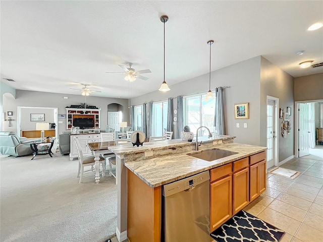 kitchen featuring light stone countertops, stainless steel dishwasher, light colored carpet, ceiling fan, and sink