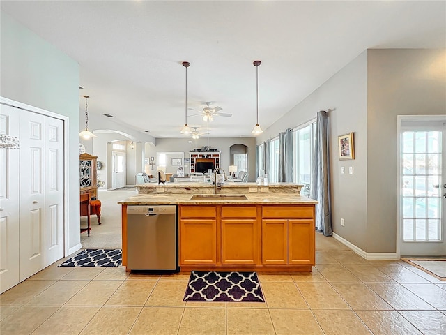 kitchen featuring stainless steel dishwasher, ceiling fan, a center island with sink, and sink