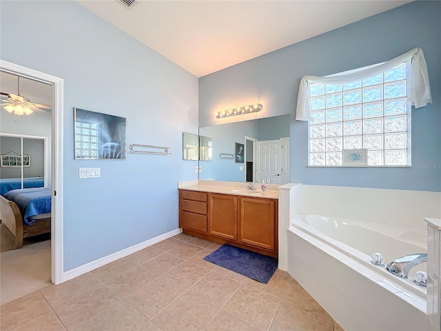 bathroom featuring vanity, tile patterned floors, ceiling fan, and tiled tub