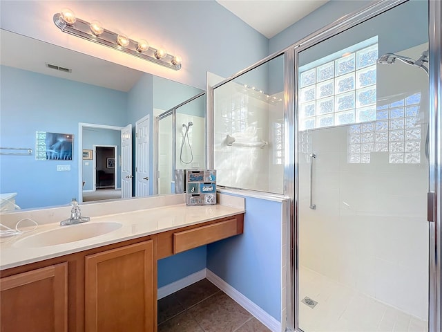 bathroom with tile patterned floors, vanity, and walk in shower