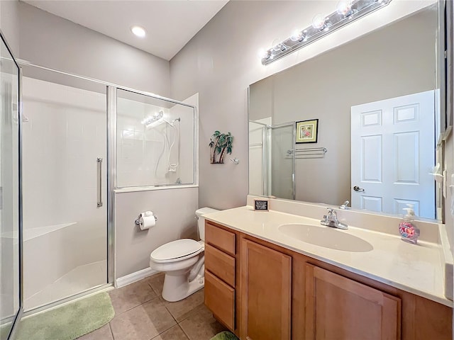 bathroom with toilet, vanity, tile patterned floors, and a shower with shower door