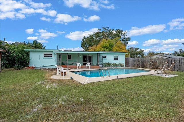 back of property featuring a yard, a fenced in pool, and a patio area