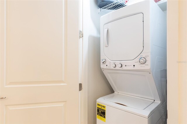 washroom with stacked washing maching and dryer