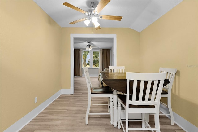 dining room with lofted ceiling and light wood-type flooring