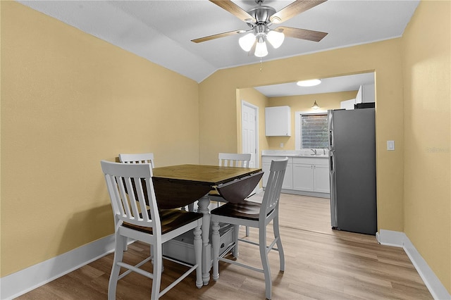 dining area with lofted ceiling, sink, light hardwood / wood-style flooring, and ceiling fan