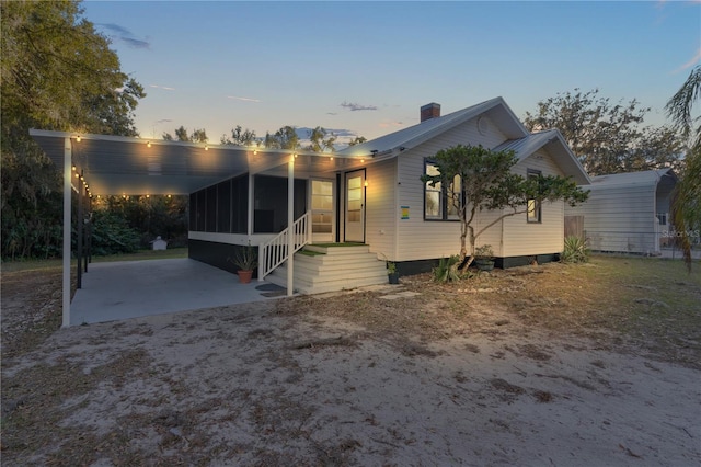 view of front of house featuring a sunroom and a carport