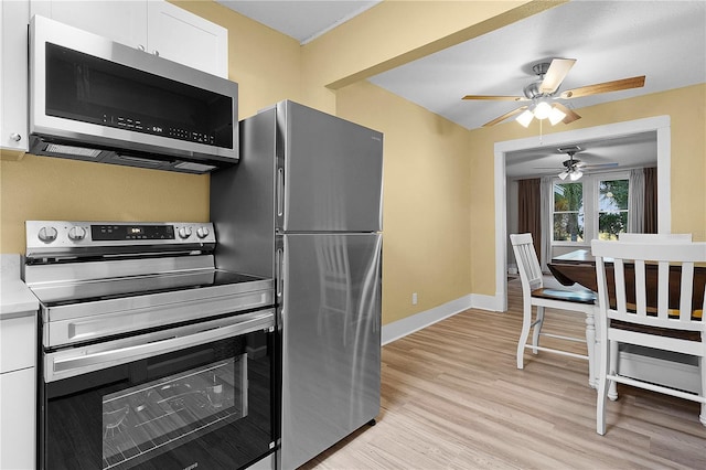 kitchen featuring stainless steel appliances, white cabinets, and light wood-type flooring