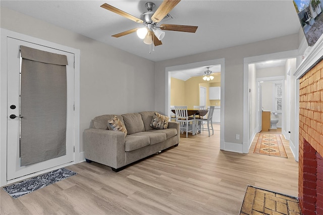 living room featuring ceiling fan and light hardwood / wood-style floors