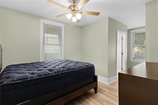 bedroom with ceiling fan and light hardwood / wood-style flooring