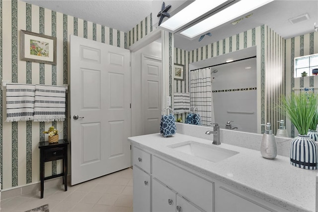 bathroom featuring tile patterned floors, vanity, curtained shower, and a textured ceiling