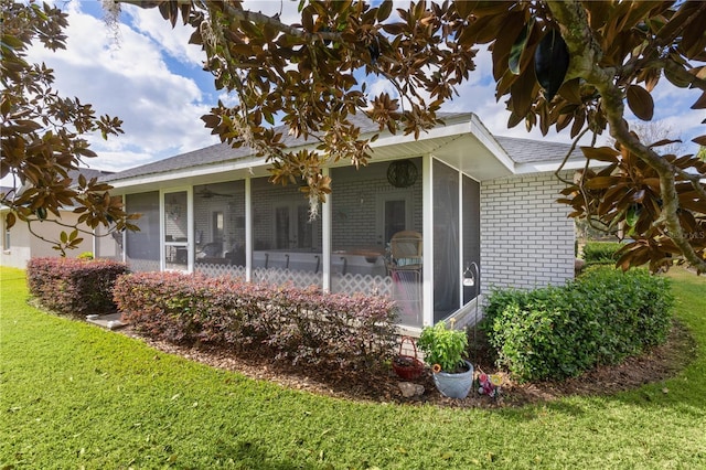 back of property with a sunroom and a yard