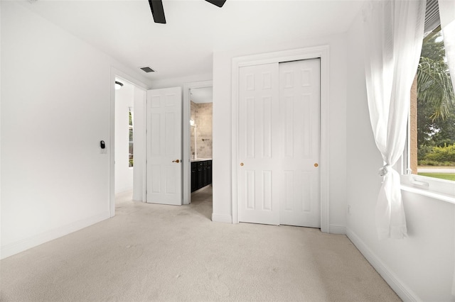 unfurnished bedroom with ceiling fan, a closet, and light colored carpet